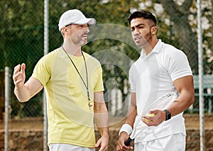 Whats the best course of action here. a handsome male coach giving instructions to his younger tennis student on a court
