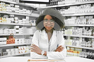 Whats on the menu today. Portrait of a cheerful young female pharmacist standing with arms folded while looking at the