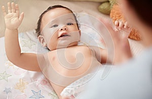 Whats my outfit today, Mom. a woman changing her adorable baby girls diaper at home.