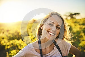 Whats not to love about living on a farm. Portrait of a happy young woman working on a farm.