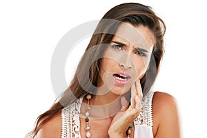 Whats the root cause of your tooth ache. Studio shot of a young woman experiencing toothache against a white background.