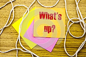 Whats up - word on yellow sticky note in wooden background. Bussines concept.