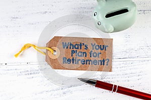 Whats Your Plan for Retirement. Cardboard price tag and piggy bank on a wooden table