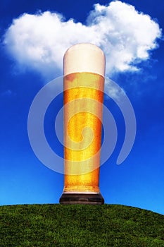 Wheat beer glass on green meadow