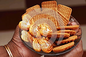 Wheat biscuits in the plate holding q woman. Indian biscuits popularly known as Chai-biscuit in India