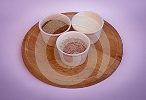 Wheat bran, yogurt and mix of them in white bowls on wooden plate