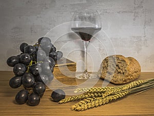 A wheat bread and red grapes with wine