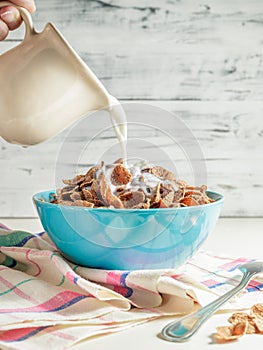 Wheat buckwheat bran breakfast cereal with milk in ceramic bowl