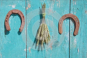 Wheat bunch and two horseshoe luck symbol on wooden barn wall