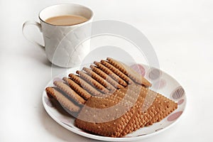 Wheat Coconut biscuits in white plate, Indian biscuits popularly known as Chai-biscuit in India, chai or chaha in india. Tea Time