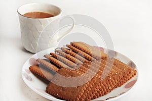 Wheat Coconut biscuits in white plate, Indian biscuits popularly known as Chai-biscuit in India, chai or chaha in india. Tea Time