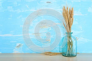 wheat crops over table and blue wooden background. Symbols of jewish holiday - Shavuot