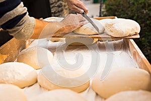 Wheat dough shaped into loaves arranged in rows on the table before baking