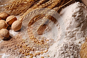 Wheat ears and flour on table, closeup. Food ingredients