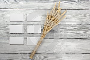 Wheat Ears on Wooden Table with blank business cards. Sheaf of Wheat over Wood Background. Harvest concept.