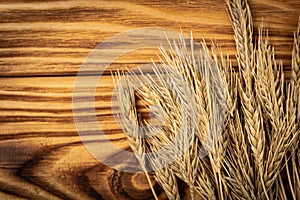 Wheat Ears on the Wooden Table. Sheaf of Wheat over Wood Background.