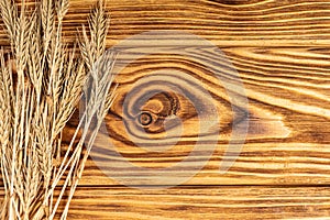 Wheat Ears on the Wooden Table. Sheaf of Wheat over Wood Background.