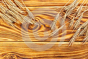 Wheat Ears on the Wooden Table. Sheaf of Wheat over Wood Background.