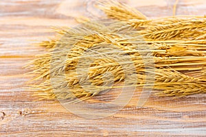 Wheat Ears on the Wooden Table. Sheaf of Wheat over Wood Background. Harvest concept