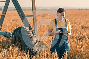 Wheat farmer using tablet in cereal crop field