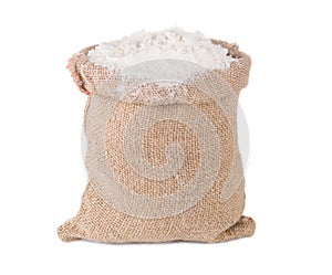 Wheat flour in burlap sack bag on white background