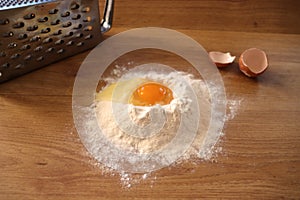 Flour with an egg on wooden background. Baking in my kitchen.