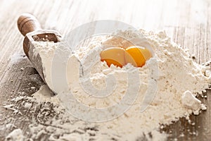 Wheat flour and eggs on bakery table ready for the preparation of dough cake or pasta