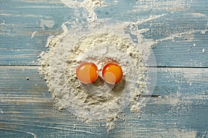 Wheat flour and eggs on wooden table - horizontal