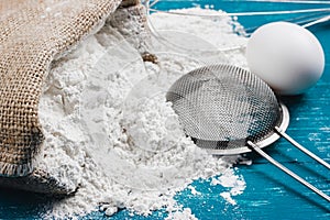 Wheat flour and a sieve on the kitchen table. Sift flour.