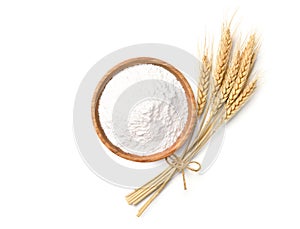 Wheat flour in wooden bowl with wheat spikelets