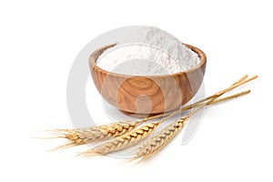 Wheat flour in wooden bowl with wheat spikelets