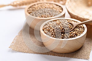 Wheat grain in a wooden bowl with spoon