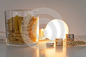 Wheat, light bulb, coins and pasta. Price of wheat, pasta, and energy. photo