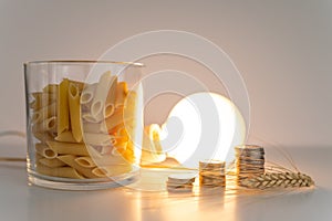 Wheat, light bulb, coins and pasta. Price of wheat, pasta, and energy. photo