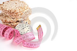 Wheat loaves, measuring tape and a stopwatch on a white background
