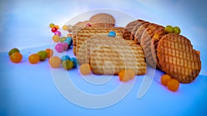 Wheat round biscuits with colorful jelly beans isolated on white background. Heap of brown delicious Cookies known as Chai biscuit