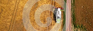 Wheat shortage, high trading prices, stockpiling. Aerial view of a combine harvester at work during harvest time.