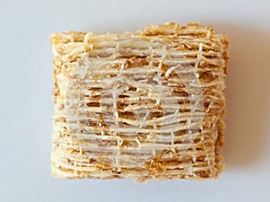 Wheat square breakfast cereal extreme closeup on white background