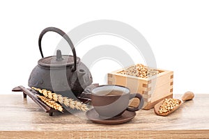 Wheat or Triticum aestivum wheat kernel and tea on wood table isolated on white background with clipping path