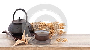 Wheat or Triticum aestivum wheat kernel and tea on wood table isolated on white background with clipping path