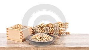 Wheat or Triticum aestivum wheat kernel on wood table isolated on white background with clipping path