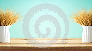 Wheat in vase on wooden table over blue background. Shavuot holiday decor mock up for design