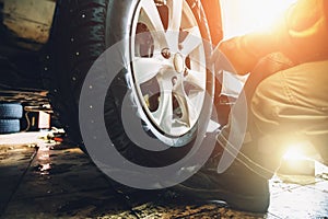 Wheel balancing or repair and change car tire at auto service garage or workshop by mechanic