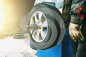 Wheel balancing or repair and change car tire at auto service garage or workshop by mechanic