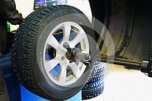 Wheel balancing or repair and change car tire at auto service garage or workshop by mechanic