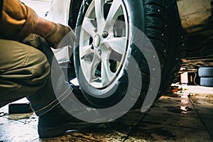 Wheel balancing or repair and change car tire at auto service garage or workshop by mechanic