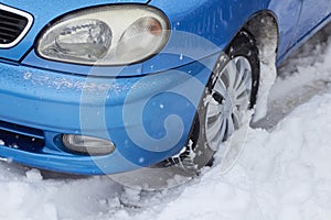 A wheel of the car is driving in the snow,close-up of a car driving through the snow in winter