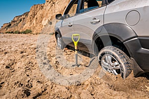 The wheel of the car got stuck in the sand
