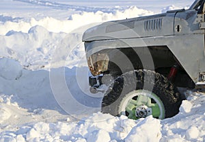 The wheel of the car is stuck in the snow. spray of snow from the rotating wheel of winter tires. slipping machine in the snow. th