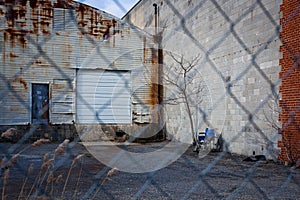 Wheel chair parked at a loading dock behind a chain link fence